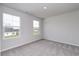 Sunlit bedroom featuring carpeted floor, neutral paint, and two large windows at 667 Mccorkle Place, Conway, SC 29526