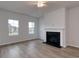 Cozy living room featuring a fireplace, hardwood floors, and large windows offering natural light at 667 Mccorkle Place, Conway, SC 29526