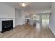 Open-concept living room with a fireplace, ceiling fan, and view into the modern kitchen at 667 Mccorkle Place, Conway, SC 29526