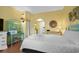 Bright bedroom with a queen bed, vintage turquoise shelving and light yellow walls at 6803 Ocean Blvd. N # 109, Myrtle Beach, SC 29572