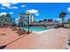 Outdoor pool with brick patio, loungers, and community buildings in the background at 6803 Ocean Blvd. N # 109, Myrtle Beach, SC 29572
