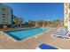 Bright pool area with lounge chairs, palm trees, and a fun splash pad for ultimate relaxation at 6803 Ocean Blvd. N # 109, Myrtle Beach, SC 29572