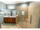Bright bathroom featuring dual sinks, updated shower with glass door, and earth-toned tile at 828 Sail Ln. # 203, Murrells Inlet, SC 29576