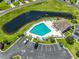 Aerial view of the community pool with lounge chairs and a nearby pond at 828 Sail Ln. # 203, Murrells Inlet, SC 29576