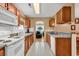 Bright kitchen with tile floors, wood cabinets, and an opening to the living room area at 9514 Leeds Circle, Myrtle Beach, SC 29588