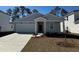 Charming single-story home boasts a well-manicured lawn, attached garage, and inviting front entrance at 981 Laconic Dr., Myrtle Beach, SC 29588