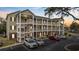Beige three-story condo building with covered staircases and parking at 1058 Sea Mountain Hwy. # 14-302, North Myrtle Beach, SC 29582