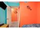 Cheerful bedroom with a vibrant orange accent wall and ocean themed decor at 123 Dogwood Dr. N # 205-A, Murrells Inlet, SC 29576