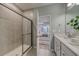 Modern bathroom featuring a tiled shower, double sink vanity, and an open view to the bedroom at 1275 Winding Creek Way, Myrtle Beach, SC 29588