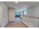 Hallway with neutral carpet and white railings leads into living area with lots of natural light at 1275 Winding Creek Way, Myrtle Beach, SC 29588