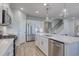 Modern kitchen with stainless appliances, white cabinets, island with sink, and wood floors at 1275 Winding Creek Way, Myrtle Beach, SC 29588