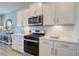 A modern kitchen features stainless steel appliances, white cabinets, a subway tile backsplash, and quartz countertops at 1275 Winding Creek Way, Myrtle Beach, SC 29588