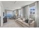 Spacious living room with neutral palette, plush sofa, and bright windows dressed with elegant white curtains at 1275 Winding Creek Way, Myrtle Beach, SC 29588