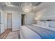Comfortable bedroom showcasing a statement light fixture, wood-look floors, and ensuite bathroom access at 1275 Winding Creek Way, Myrtle Beach, SC 29588