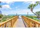 Wooden boardwalk leading to the beach with ocean view and palm trees at 205 74Th Ave. N # 1508, Myrtle Beach, SC 29572