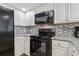Well-equipped kitchen with sleek black appliances, white cabinets, and modern countertops, perfect for culinary enthusiasts at 205 74Th Ave. N # 1508, Myrtle Beach, SC 29572