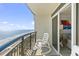 Inviting balcony with seating, offering serene views of the beach and ocean from sliding glass door at 2300 N Ocean Blvd. # 1037, Myrtle Beach, SC 29577