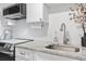 Updated kitchen featuring a stainless steel sink, modern faucet, and stylish backsplash at 2300 N Ocean Blvd. # 1037, Myrtle Beach, SC 29577