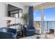 Well-lit living room offers a comfortable sitting area and expansive views from the sliding glass door at 2300 N Ocean Blvd. # 1037, Myrtle Beach, SC 29577