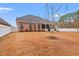 Home's back exterior features a screened-in porch, manicured lawn, and a privacy fence at 2350 Clandon Dr., Myrtle Beach, SC 29579