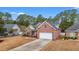 Two-story brick home featuring an attached two-car garage, manicured lawn, and mature landscaping at 2350 Clandon Dr., Myrtle Beach, SC 29579