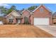 Charming brick home featuring an attached two-car garage, arched windows and lush landscaping at 2350 Clandon Dr., Myrtle Beach, SC 29579