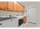 A well-lit laundry room boasts modern machines, ample cabinet space, sink, and a convenient door to the exterior at 2350 Clandon Dr., Myrtle Beach, SC 29579