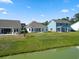 View of several homes' backyards, a small pond, and green grass at 2443 Campton Loop, Conway, SC 29527