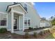 Charming home featuring a covered front porch, black front door and manicured lawn at 2476 Blue Crane Circle # 101, Myrtle Beach, SC 29577