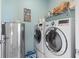 Well-equipped laundry room with modern washer, dryer, refrigerator, and shelving at 2476 Blue Crane Circle # 101, Myrtle Beach, SC 29577