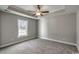 Spacious bedroom featuring a tray ceiling, neutral paint, carpet and a large window for natural light at 2582 Cottonwood Dr., Loris, SC 29569