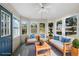 Cozy sunroom with ample windows, ceiling fan, and wood furniture with blue cushions at 3148 River Bluff Ln., Little River, SC 29566