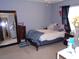 This bedroom features a large mirror, a cozy bed with pillows, and dark curtains at 3158 River Bluff Ln., Little River, SC 29566