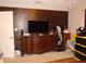 Main bedroom featuring dark wood accent wall, dresser, TV, and closet space at 3158 River Bluff Ln., Little River, SC 29566