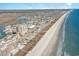 Aerial view of a coastal community featuring oceanfront homes along a sandy beach at 4103 N Ocean Blvd. # 207, North Myrtle Beach, SC 29582