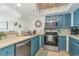 Well-equipped kitchen with stainless steel appliances, blue cabinets, and tile backsplash at 4103 N Ocean Blvd. # 207, North Myrtle Beach, SC 29582