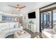 Open-concept living room featuring a white couch, modern ceiling fan, and sliding glass doors at 4103 N Ocean Blvd. # 207, North Myrtle Beach, SC 29582