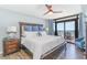 Inviting main bedroom featuring a ceiling fan, dark wood floors and furniture, plus ocean views from a private balcony at 4103 N Ocean Blvd. # 207, North Myrtle Beach, SC 29582