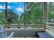 Relaxing screened-in balcony offering a picturesque view of lush trees and landscaping at 415 Ocean Creek Dr. # 2202, Myrtle Beach, SC 29572