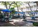 Charming courtyard with outdoor seating, blue umbrellas, and a decorative water fountain surrounded by trees at 415 Ocean Creek Dr. # 2202, Myrtle Beach, SC 29572