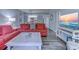 Comfortable living room featuring a red sofa, a white coffee table, and a view into the kitchen at 415 Ocean Creek Dr. # 2202, Myrtle Beach, SC 29572