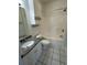 Clean bathroom with a tiled floor, shower-tub combo, granite vanity, and wall-mounted storage at 4155 Hibiscus Dr. # 103, Little River, SC 29566