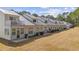 Row of townhomes shows backyard patio areas and second story balconies at 437 Colonial Trace Dr. # 2C, Longs, SC 29568
