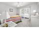 Bright bedroom with slider door leading to backyard, with a colorful striped bedspread at 437 Colonial Trace Dr. # 2C, Longs, SC 29568