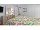 Bright bedroom with vibrant bedding, natural light, wood floors, and a dresser with mirror at 4420 Eastport Blvd. # M12, Little River, SC 29566