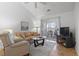 Inviting living room with sliders to balcony, neutral color palette, and vaulted ceilings at 4420 Eastport Blvd. # M12, Little River, SC 29566