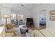 Comfortable living room features sliders to balcony, TV, and view into adjacent bedroom at 4420 Eastport Blvd. # M12, Little River, SC 29566
