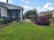 Charming backyard featuring a screened porch, patio area, and beautifully landscaped garden beds at 5318 Tremiti Ln., Myrtle Beach, SC 29579