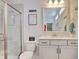 Bright bathroom with a glass shower, white vanity with drawers and a decorative mirror with light fixtures at 568 Canborough Lane, Murrells Inlet, SC 29576
