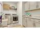Efficient laundry room features modern washer and dryer, with ample cabinet space and granite countertops at 568 Canborough Lane, Murrells Inlet, SC 29576